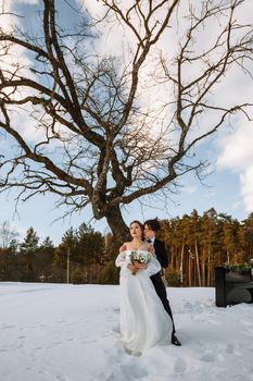 A girl in a wedding dress and a young man are standing next to the piano