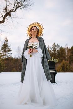 The bride is standing in a snow-covered forest.