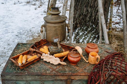 An old samovar standing on a chest in the winter forest.