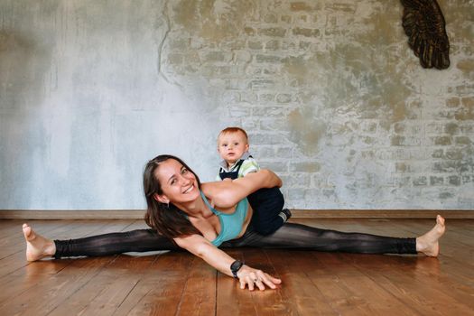 Yoga girl lies on the floor, on a wide splits and smiles