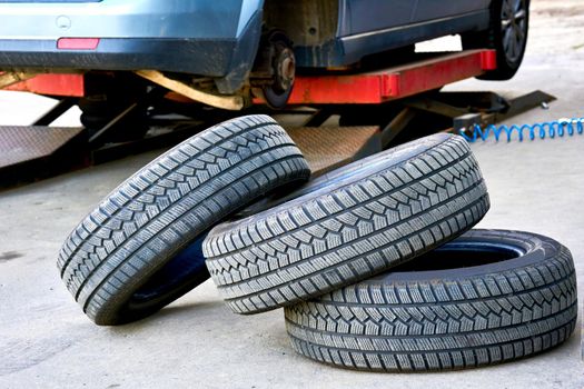 Replacing a car wheel at a tire station. a rubber covering, typically inflated or surrounding an inflated inner tube, placed around a wheel to form a flexible contact with the road.