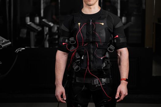 EMS suit with red wires for electro impulse stimulation for body. Training in GYM