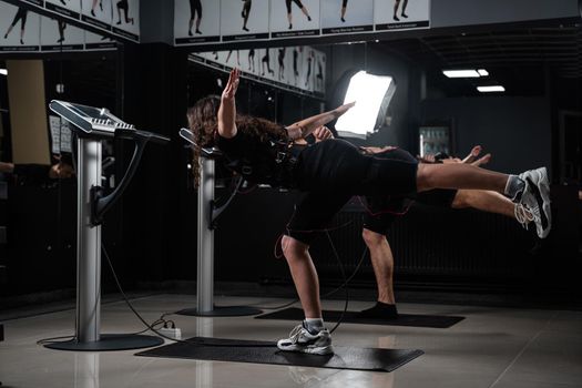 EMS group training for two men and women in the gym. Electrical stimulation for muscles of body