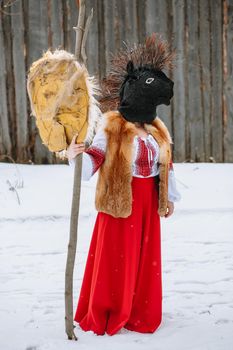 A man in a national costume with the head of an animal celebrates the arrival of the pagan holiday Maslenitsa.