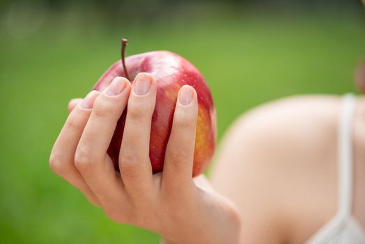 Close-up of the woman's hand with an apple.