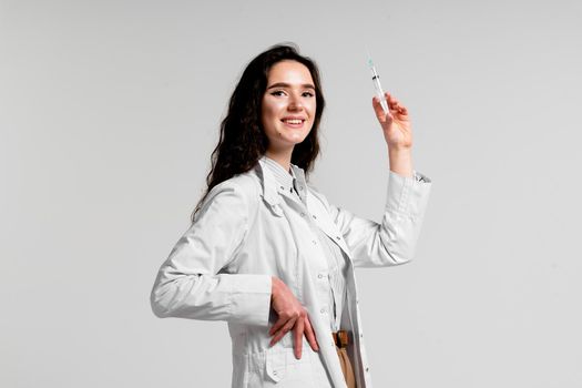 Doctor holding syringe with coronavirus vaccine. Covid-19 Vaccination. Stop quarantine. Attractive girl in medical gloves with syringe and medication