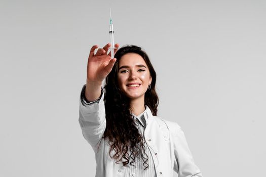 Doctor holding syringe with coronavirus vaccine. Covid-19 Vaccination. Stop quarantine. Attractive girl in medical gloves with syringe and medication