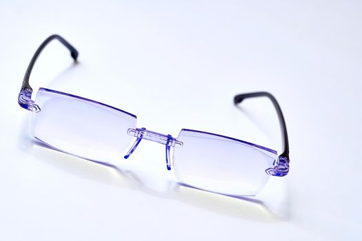 a pair of lenses set in a frame resting on the nose and ears, used to correct or assist defective eyesight or protect the eyes.