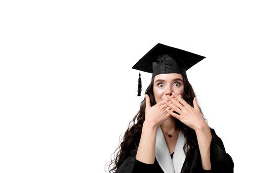 Surprised bachelor girl in graduation robe and cap on white background. Happy and funny young woman smile. Student achieve master degree in univesity