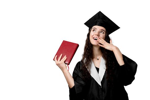 Student with book in graduation robe and cap ready to finish college. Future leader of science. Academician young woman in black gown smiling.