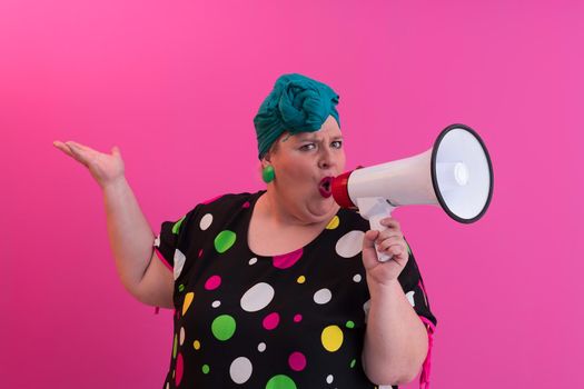 Funny plus size woman woman girl posing isolated on pastel pink wall background studio portrait. People sincere emotions lifestyle concept. Mock up copy space. Screaming in megaphone. High quality photo