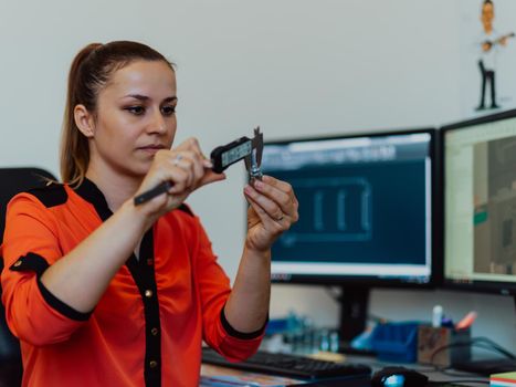 Within the heavy industry, a factory industrial engineer measures with a caliper and on a personal computer Designs a 3D model. High quality photo