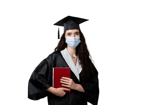 Student with book in graduation robe and cap in medical mask at coronavirus covid-19 period. Future leader of science. Academician young woman in black gown smiling.