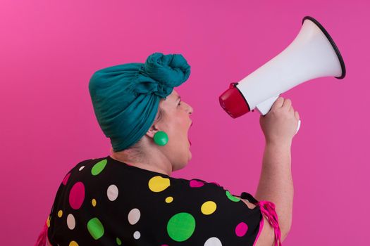 Funny plus size woman woman girl posing isolated on pastel pink wall background studio portrait. People sincere emotions lifestyle concept. Mock up copy space. Screaming in megaphone. High quality photo