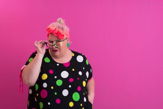 Happy Plus Size Woman Wearing Eyeglasses Smiling To Camera Standing Over Pink Background. Cheerful Millennial Female In Eyewear Posing In Studio. High quality photo