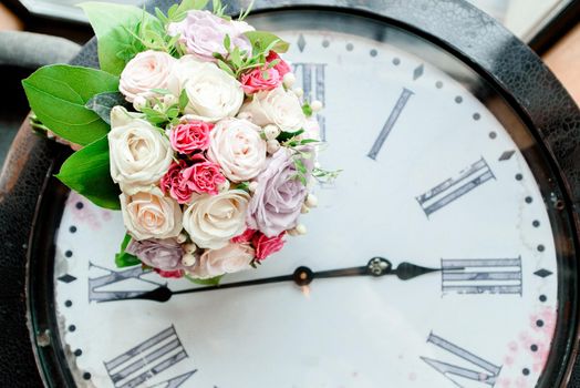 Beautiful wedding bouquet on the background of the clock.