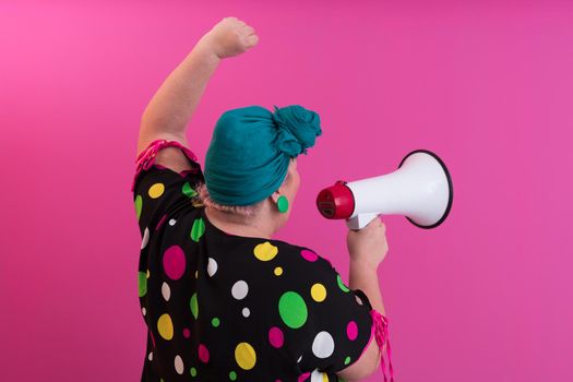 Funny plus size woman woman girl posing isolated on pastel pink wall background studio portrait. People sincere emotions lifestyle concept. Mock up copy space. Screaming in megaphone. High quality photo