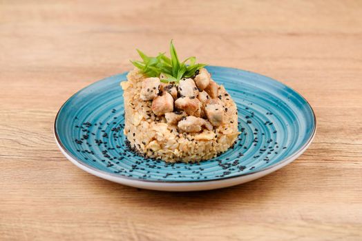 Chinese roasted rice topped with chiken and spring onion on blue plate
