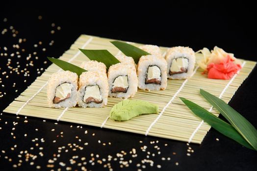 Sushi roll sea food on black background. Sushi delivery from the restaurant. Fresh delicious Japanese sushi with avocado, cucumber, shrimp and caviar on dark background