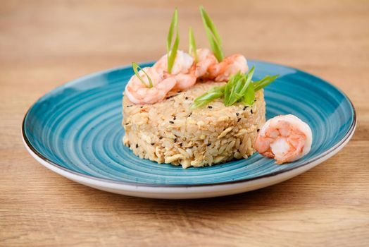 Chinese roasted rice topped with chiken and spring onion on blue plate
