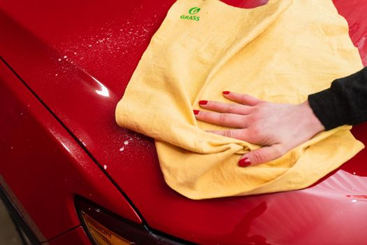 Car polishing with yellow microfiber cloth. Protection of paintwork.