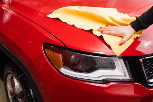 Car polishing with yellow microfiber cloth. Protection of paintwork.