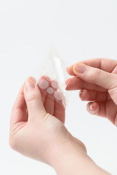 Round patches for acne and wrinkles on the hands on a white background. Acne and wrinkle patches for facial rejuvenation. Facial cleansing cosmetology.