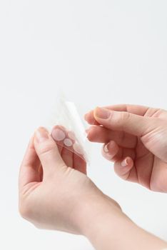 Round patches for acne and wrinkles on the hands on a white background. Acne and wrinkle patches for facial rejuvenation. Facial cleansing cosmetology.