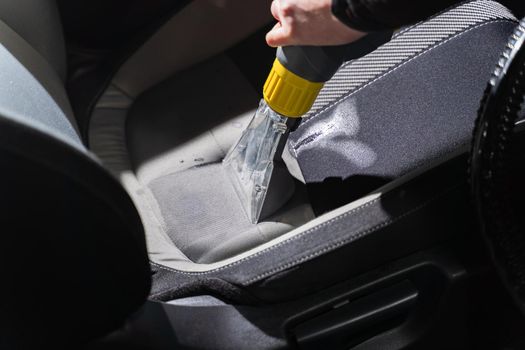 Cleaning car salon dry cleaning with vacuum cleaner. Professional use of a steam vacuum cleaner to remove stains