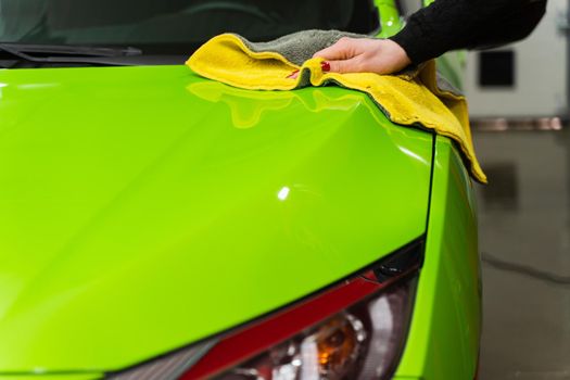 Car polishing with yellow microfiber cloth. Protection of paintwork.