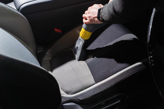 Cleaning car salon dry cleaning with vacuum cleaner. Professional use of a steam vacuum cleaner to remove stains