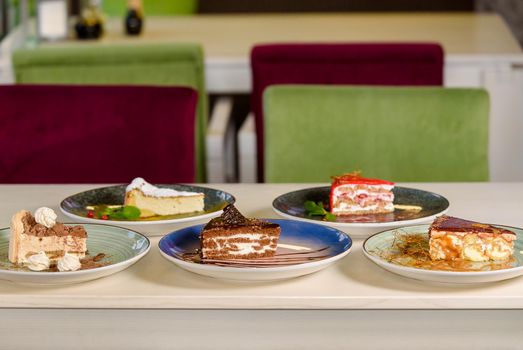 Assortment of pieces of cake on table, copy space. Several slices of delicious desserts, restaurant menu concept.
