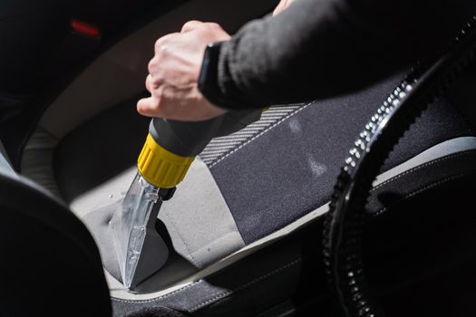 Cleaning car salon dry cleaning with vacuum cleaner. Professional use of a steam vacuum cleaner to remove stains