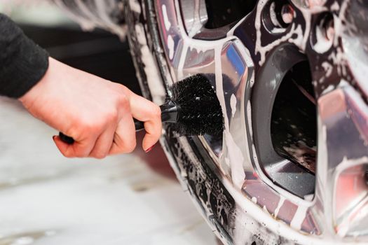 Car cleaning cast silver car rims using a brush