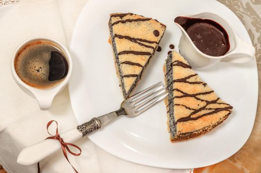 German poppy seed cake on white plate with chocolate and coffee