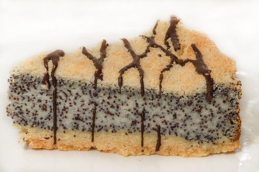 German poppy seed cake on white plate with chocolate and coffee