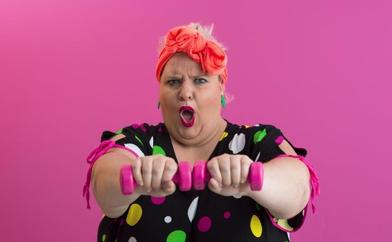 Fat woman dieting, fitness and healthy food at home.Big woman and sport. Health, fitness and sports concept. Plus size young woman doing exercise with dumbbells on pink background. High quality photo