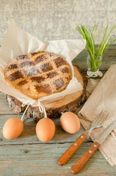 Neapolitan Easter cake with ricotta and wheat on old wooden table. Next egg, knife and fork. Rustic style.