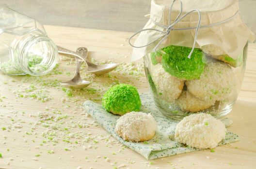 Sugar cookies with coconut flakes in glass jar. Near napkin. Selective focus