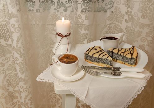 German poppy seed cake on white plate with chocolate and coffee