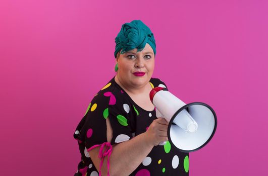 Funny plus size woman woman posing isolated on pink background studio portrait. People emotions lifestyle concept. Mock up copy space. Screaming in megaphone. High quality photo