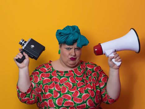 Funny plus size woman posing isolated on yellow background studio portrait. Overweight lady screaming in a megaphone. People emotions lifestyle concept. Mock up copy space. High quality photo