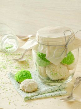 Sugar cookies with coconut flakes in glass jar. Near napkin