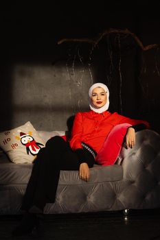 Muslim woman near christmas lights and decoration in studio. Professional muslim model posing at the new year eve.