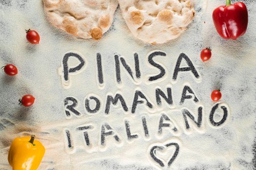 Dough and flour with text pinsa romana italiano on black background. Scrocchiarella gourmet italian cuisine. Traditional dish in italy