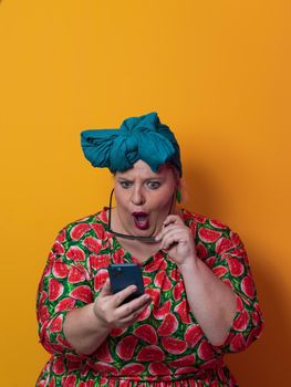 Trendy plus size woman having conversation talking by smartphone over yellow background smiling with an idea or question pointing finger with happy face, number one. High quality photo