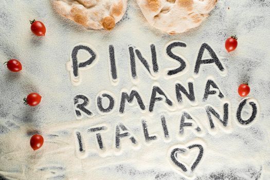 Dough and flour with text pinsa romana italiano on black background. Scrocchiarella gourmet italian cuisine. Traditional dish in italy