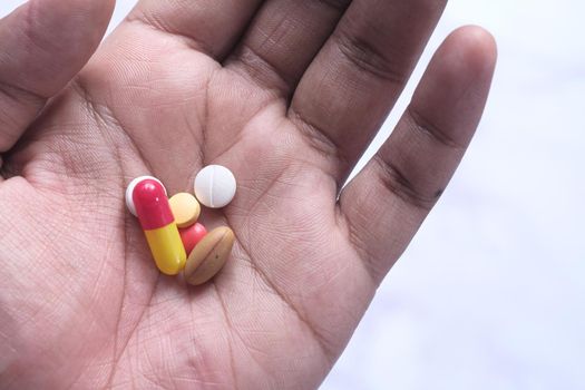 close up of pills and capsule on palm of hand .