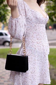 close up of womans hand holding fashionable little black bag. Product photography. stylish handbag and purse for women.