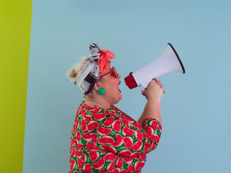 Funny plus size woman posing isolated on cyan background studio portrait. Screaming in a megaphone. People emotions lifestyle concept. Mock up copy space. High quality photo